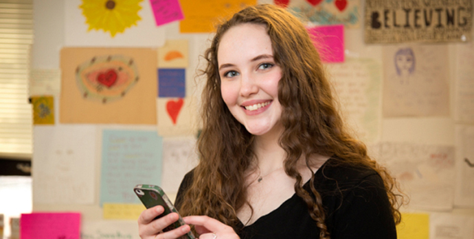 Young woman smiling and using app on phone